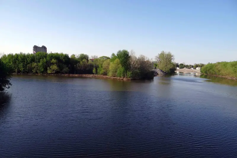 Deep blue water where the St. Marys and St. Joseph rivers meet to form the Maumee, framed by summer trees